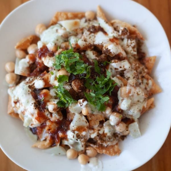 A close-up of Bombay Palace's Indian chaat, topped with yogurt, chutneys, chickpeas, and cilantro.